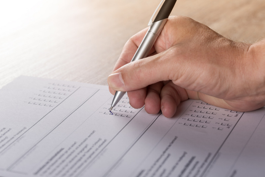Man answering a survey form using a pen